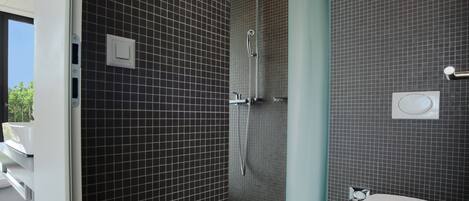 A modern bathroom with dark tiled walls, a shower, and a toilet.
