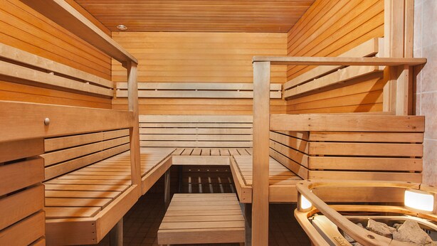 A sauna with wooden benches and a central walkway. - Hotelli Vuolake (Laukaa)