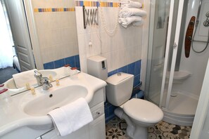A bathroom with a sink, toilet, and shower.