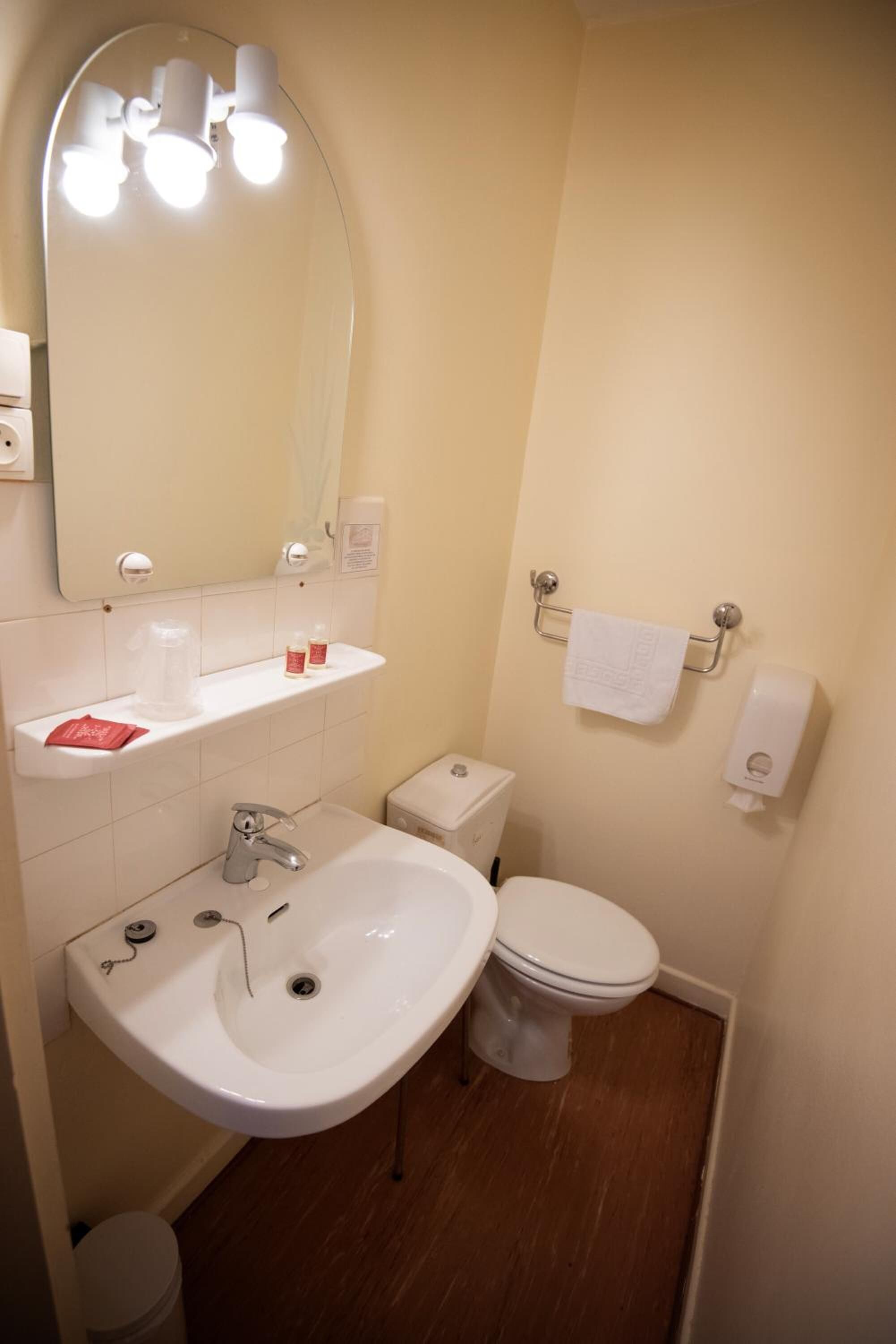 Une petite salle de bain avec un lavabo, des toilettes et un miroir.