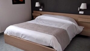 Una camera da letto moderna con un letto a telaio in legno, biancheria da letto bianca e due abat-jour.