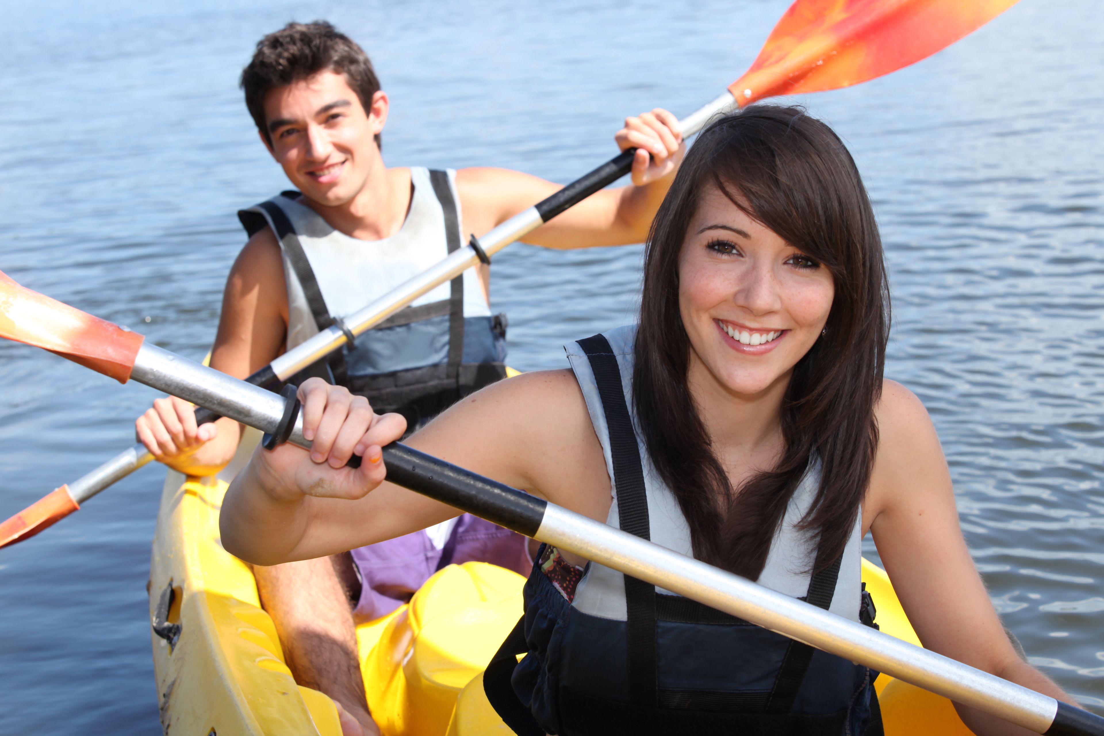 A person in a yellow kayak on a body of water.