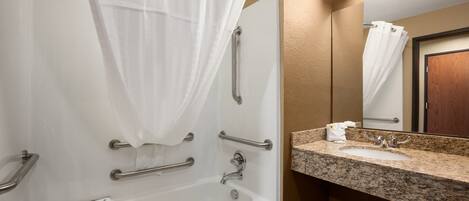 A bathroom with a bathtub, a sink, and a mirror.
