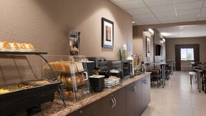 Ein Hotel-Frühstücksbereich mit Buffet, verschiedenen Speisen und einer Kaffeestation.