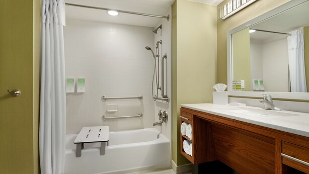 Un baño con ducha, bañera, lavamanos y tocador.
