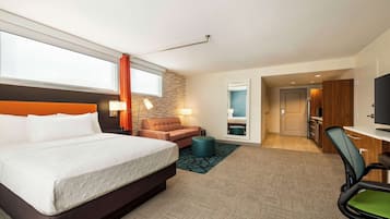 Una camera d'albergo con un letto, una scrivania, una sedia, un divano e una televisione.