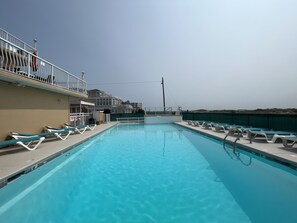 A swimming pool with lounge chairs and a balcony with railings. - Granada Ocean Resort (Wildwood Crest)