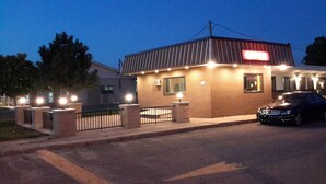 A brick building with a metal roof and a lit sign. - Motel Ritz (Gatineau)