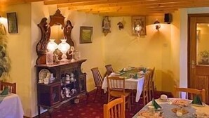 A dining area with a wooden ceiling, a table set for a meal, and a cabinet with dishes. - Salmon Leap Farm B&B (Killarney)
