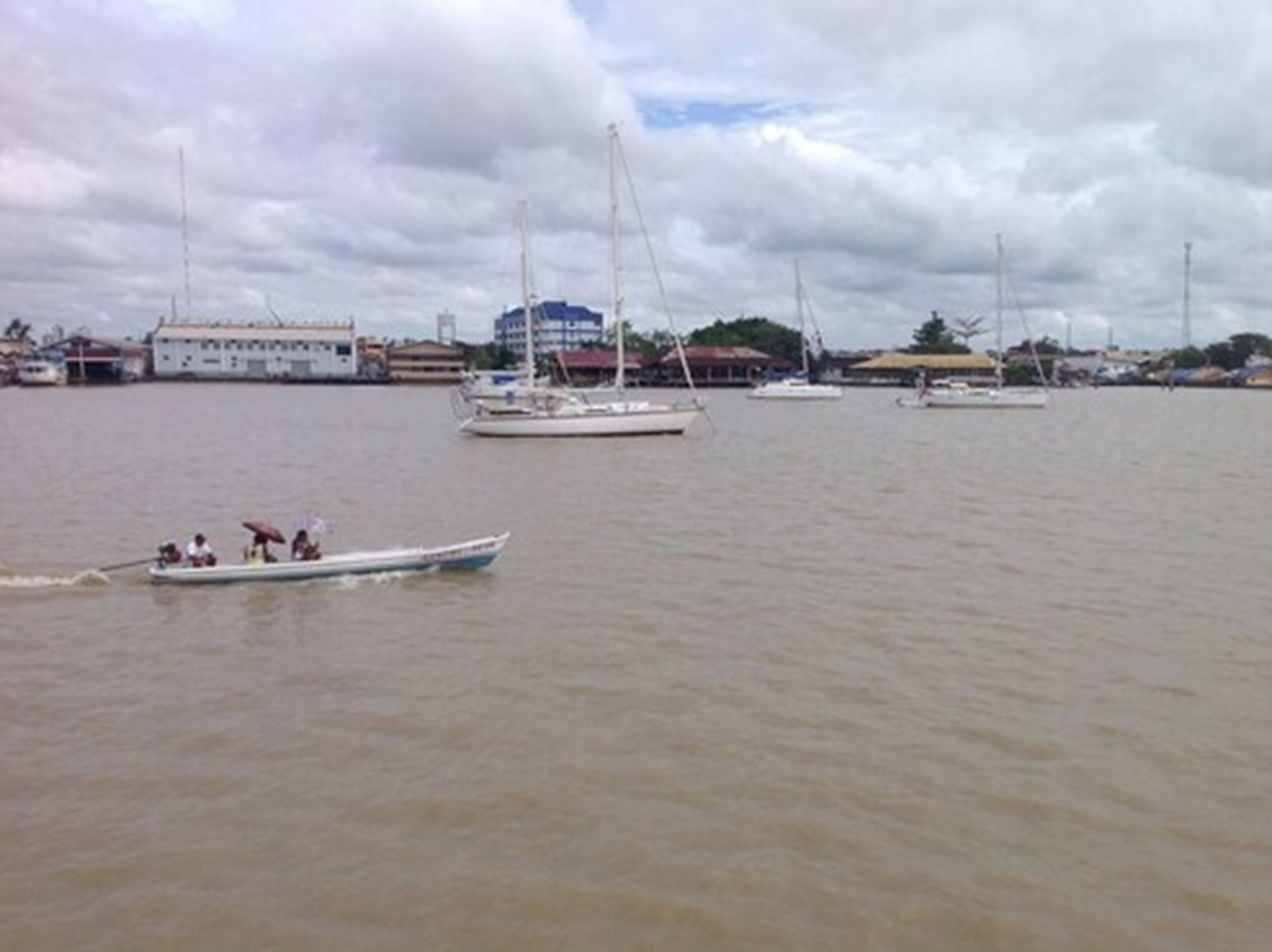 Marina com vários veleiros e um barco a motor.