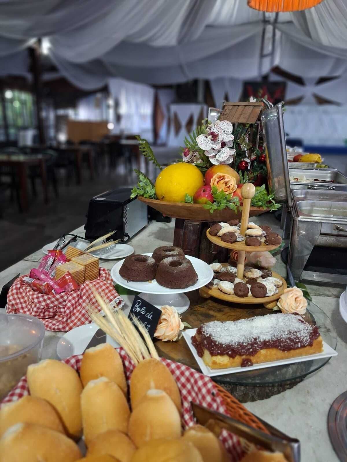 En buffet med forskellige bagværk, herunder kager og tærter, anrettet på et borddække.
