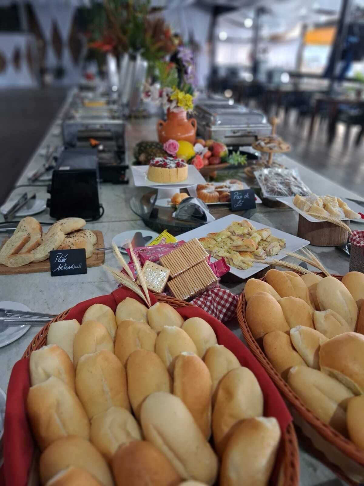 Una mesa de buffet con diferentes opciones de comida, incluyendo pan, pasteles y un pastel.