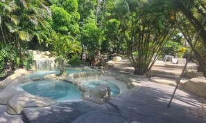 A naturalistic garden with a hot spring, rock formations, and dense tropical foliage. - Hotel Amazônico (Belém)