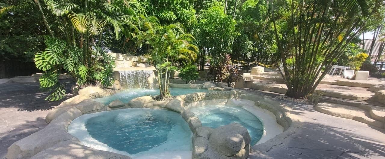 Una piscina al aire libre, sillones reclinables de piscina