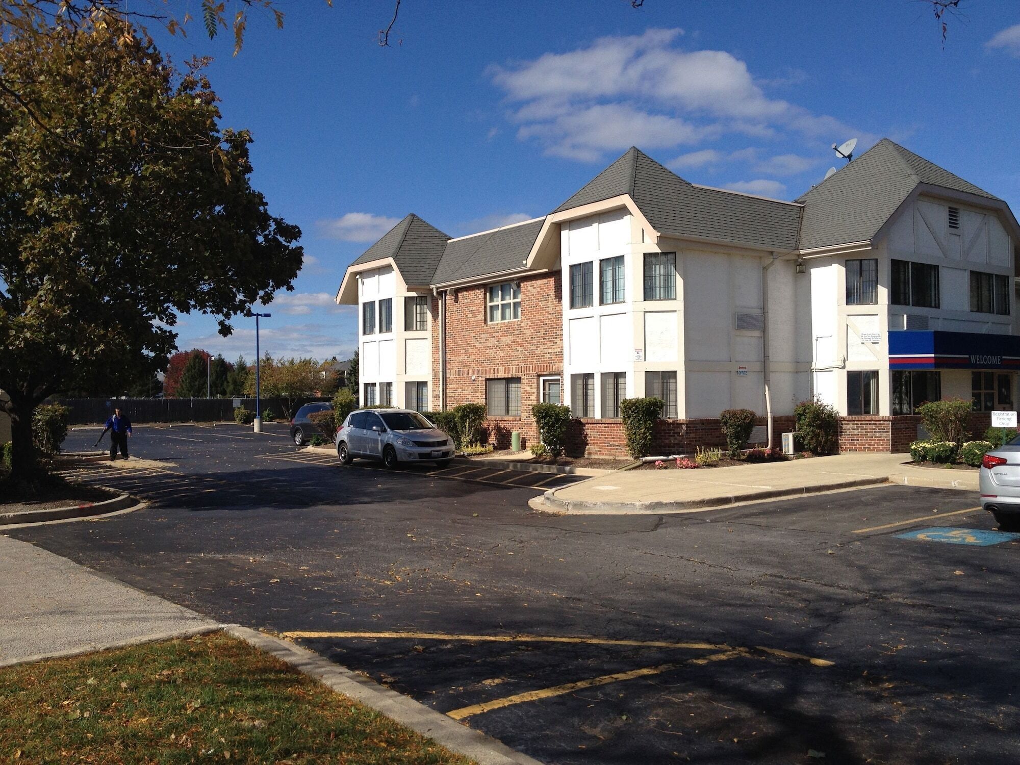 A two-story building with a parking lot in front.