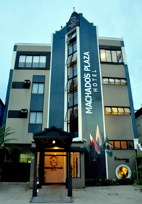 Un moderno edificio di un hotel con un cartello ben visibile che riporta la scritta "Machados Plaza Hotel".