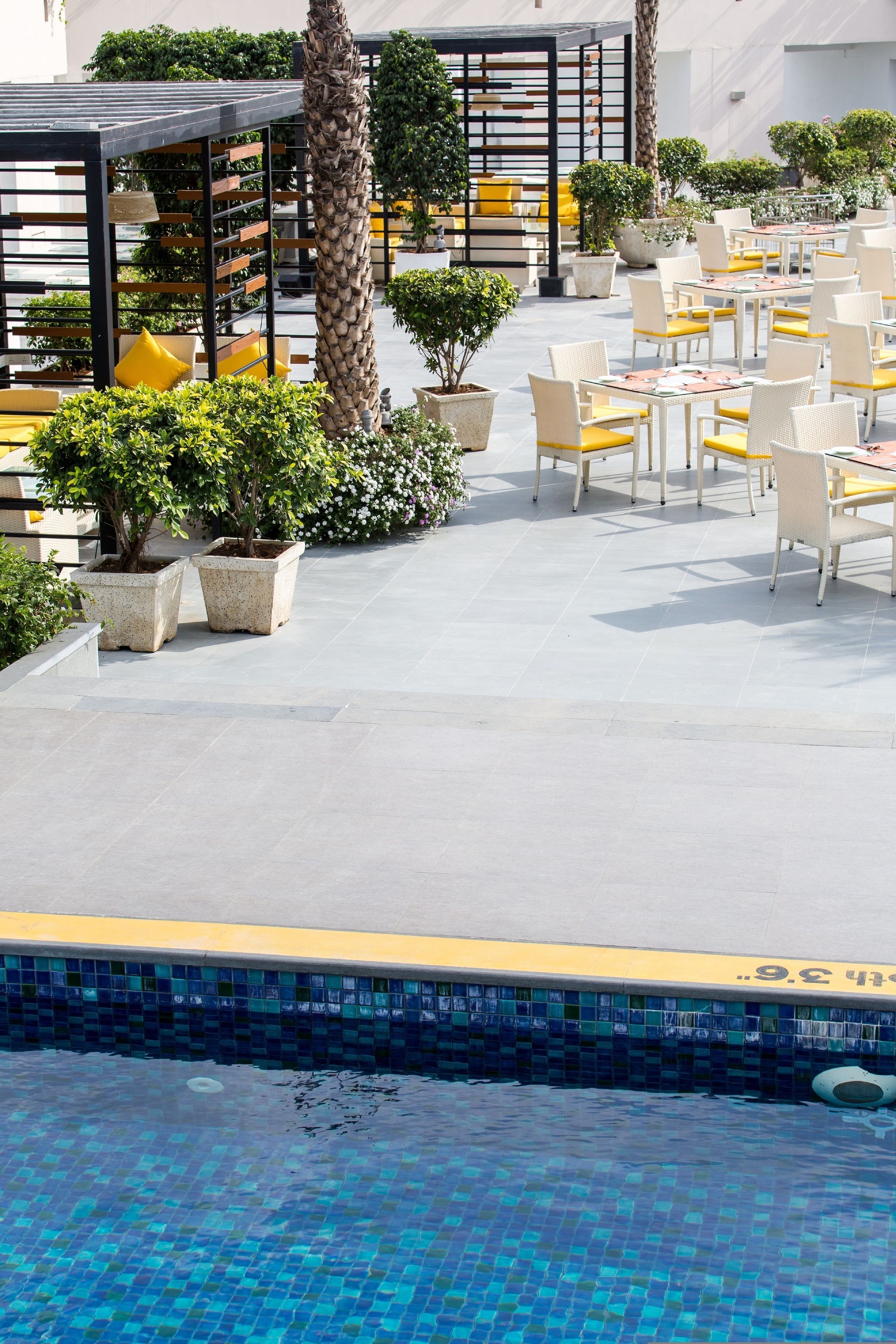 A poolside area with outdoor seating and potted plants.