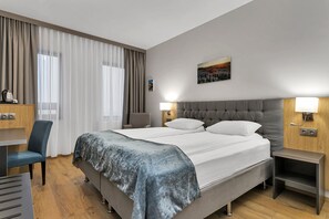 Habitación estándar con 1 cama matrimonial o 2 individuales | Escritorio, espacio para trabajar con laptop y cortinas blackout