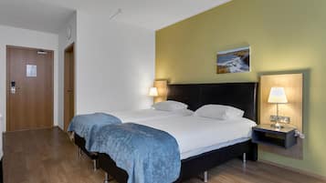 A double bed with a dark headboard, two bedside lamps, and a small bedside table.