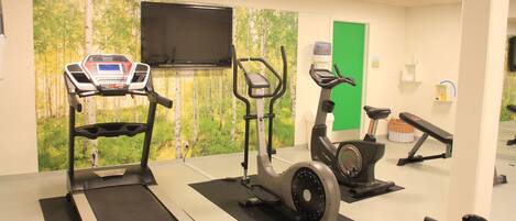 A gym with treadmills, elliptical machines, and a stationary bike.