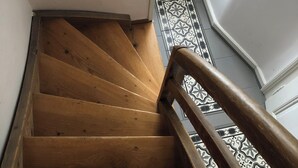 A wooden staircase with a patterned floor and a handrail. - The Bed and Breakfast (Lucerne)