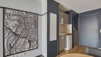 A modern kitchen with a large map artwork, built-in cabinets, and a dining area with a round table.