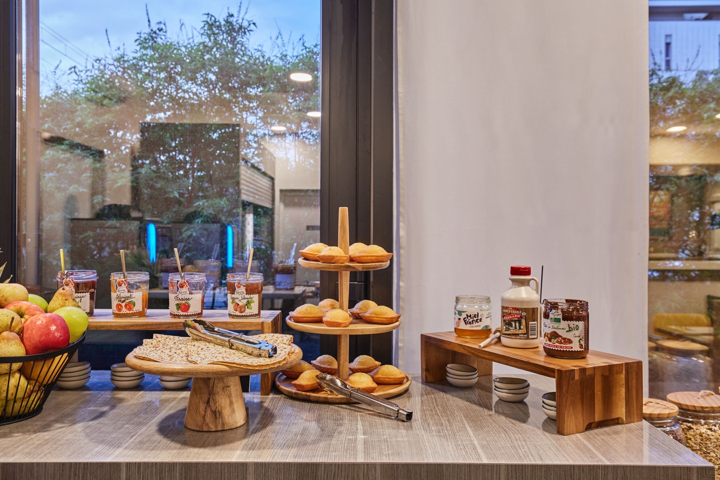 A breakfast buffet with various pastries, fruits, and condiments.