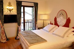 Une chambre d’hôtel avec un lit, une télévision, une lampe et une fenêtre avec des rideaux.