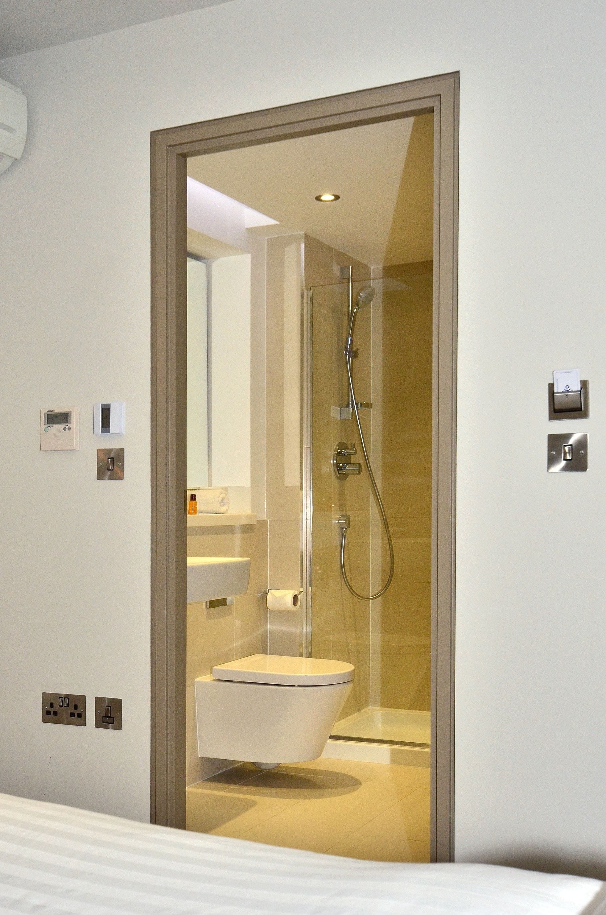 A modern bathroom with a glass-enclosed shower, a white sink, and a toilet.