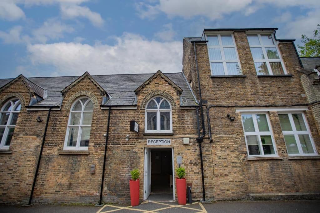 A reception area with a brick facade, arched windows, and a door labeled 'RECEPTION'.