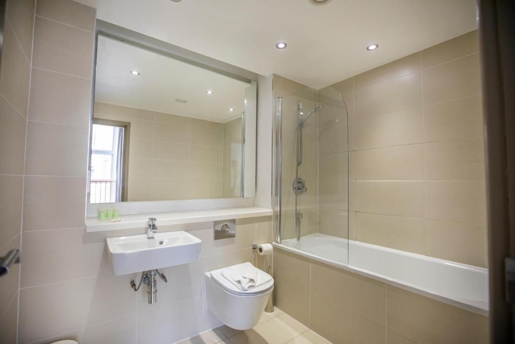 Un bagno con lavandino, water e cabina doccia in vetro.