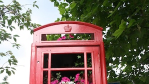 A red telephone booth with floral decorations. - Arch hotel (London)