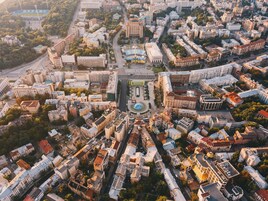 An aerial view of a cityscape with a prominent central square, surrounded by various buildings and streets.