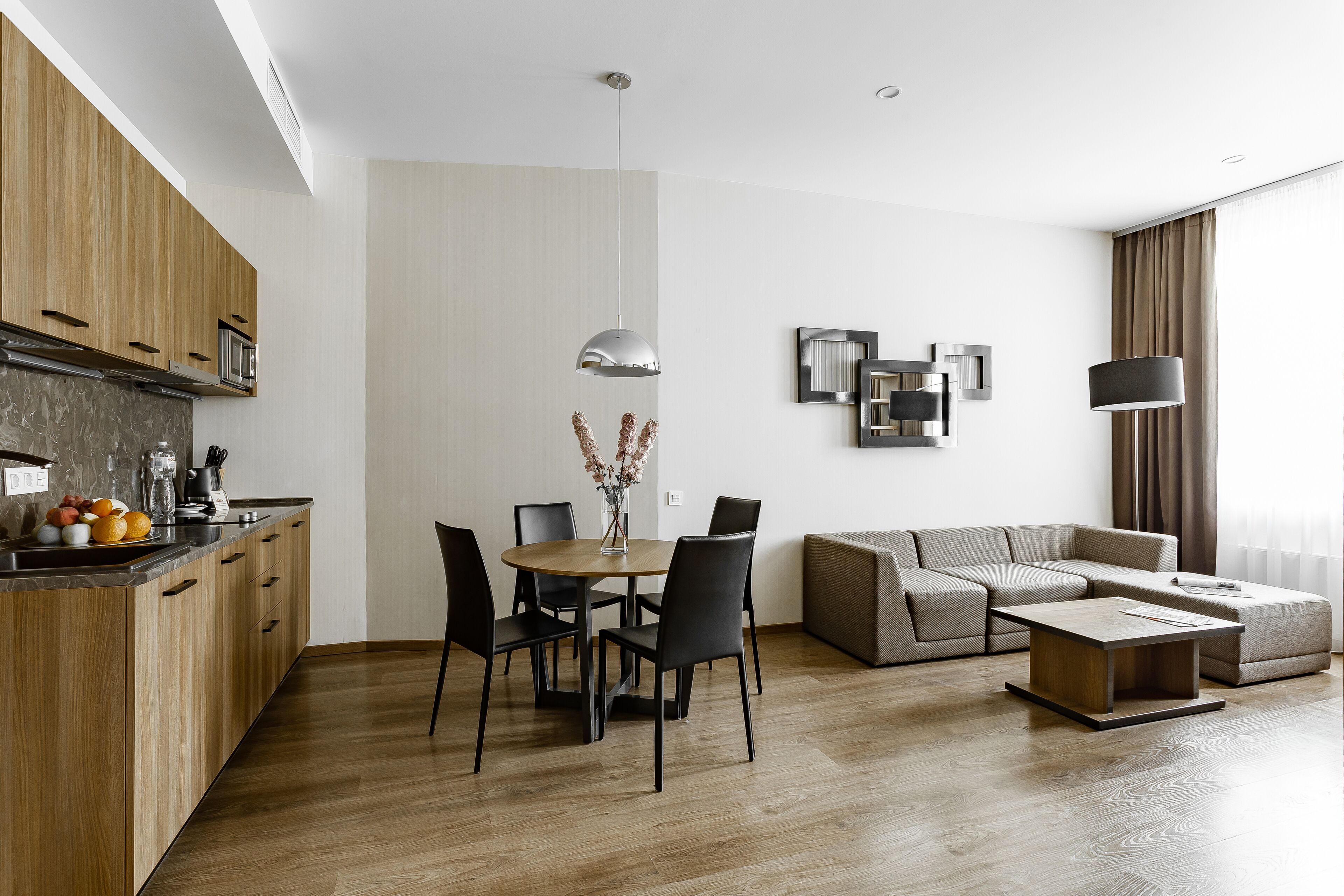 Un espace de vie moderne comprenant une cuisine, un coin repas et un coin salon.