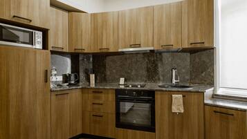 A modern kitchen with wooden cabinets, a built-in microwave, a stove, and a sink.