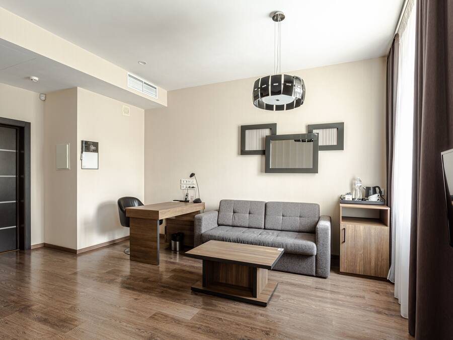 A modern living room with a sofa, a coffee table, a desk, and a TV.