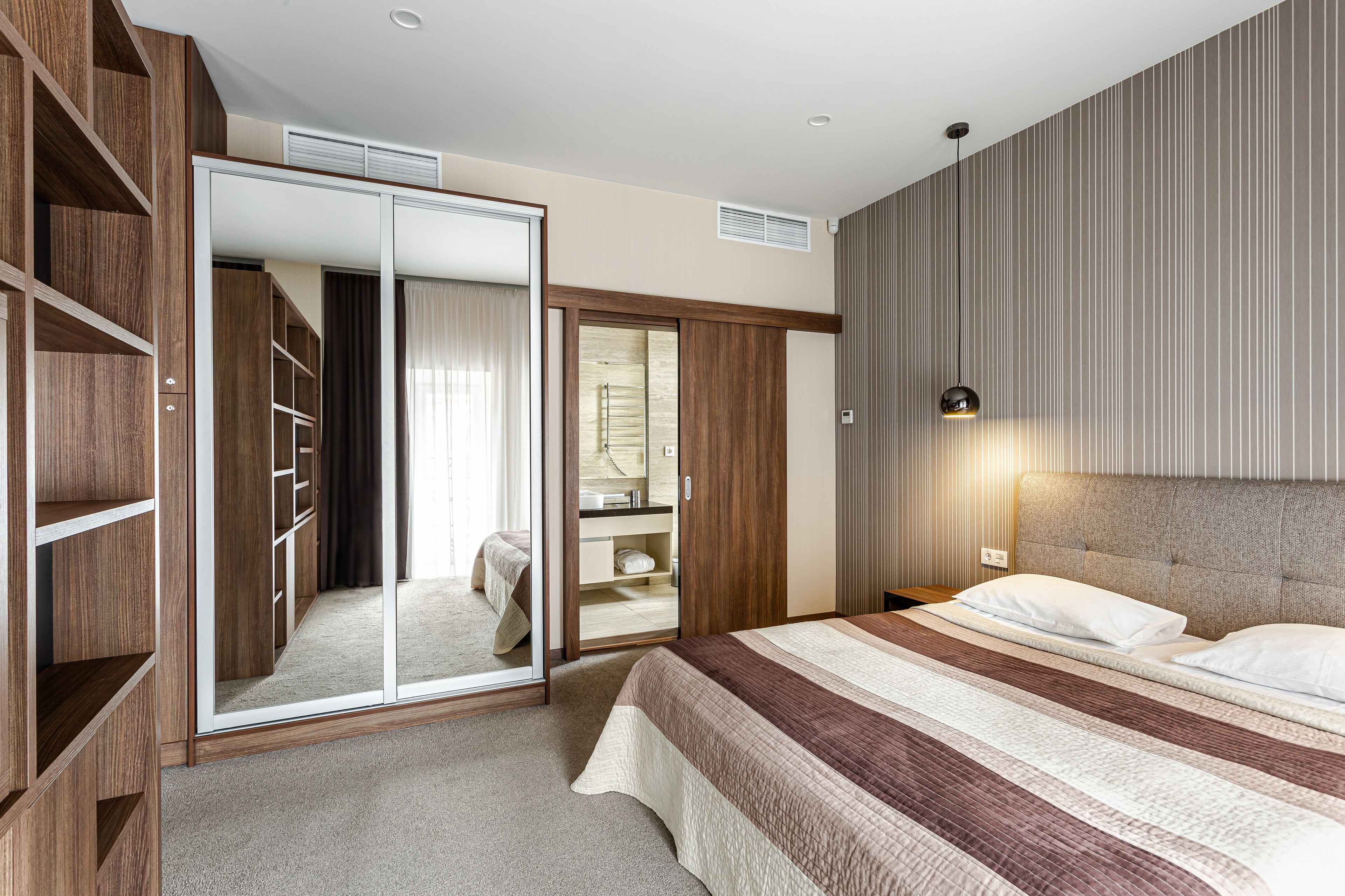 Une chambre à coucher avec un grand lit, une armoire et un miroir.