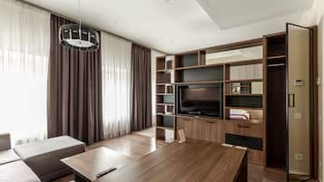 Una sala de estar moderna con una mesa de centro de madera, un sofá, un televisor y estanterías empotradas.