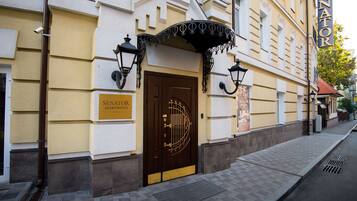 A building with a brown door and a sign that reads "SENATOR APARTMENTS."