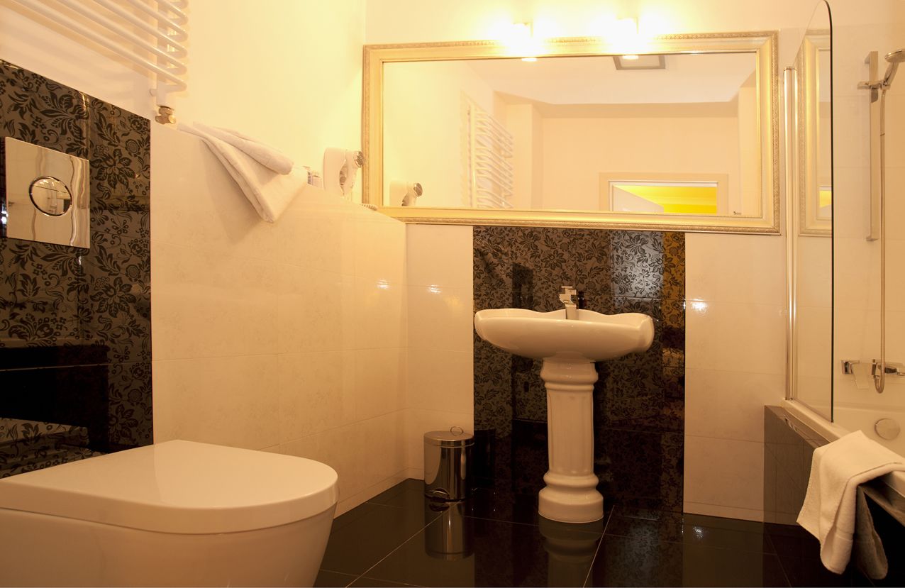 A bathroom with a toilet, sink, and mirror.