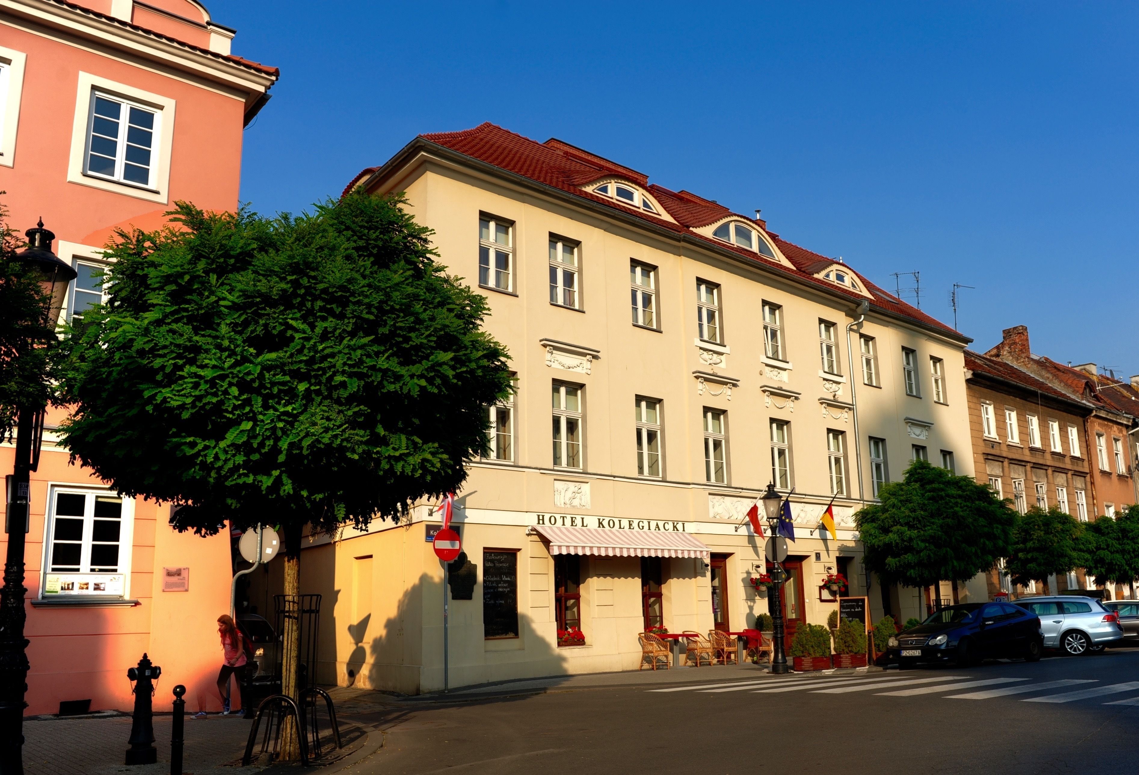 Un hôtel à la façade classique, doté de nombreuses fenêtres et surmonté d’un toit recouvert de tuiles rouges.