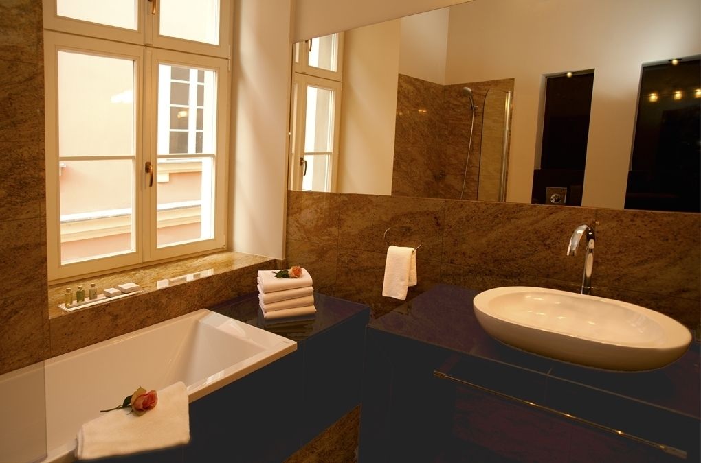 A modern bathroom with a bathtub, a large sink, and a mirror.