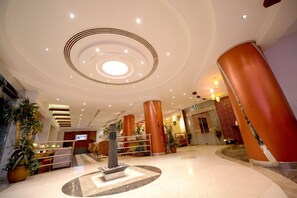 Experience the stylish lobby with a unique centerpiece, staircase, and lush greenery.