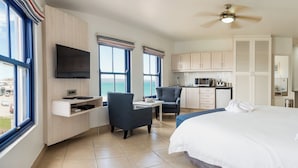 A hotel room with a bed, a desk, a chair, a TV, and a view of the sea. - Club Mykonos Langebaan (Langebaan)