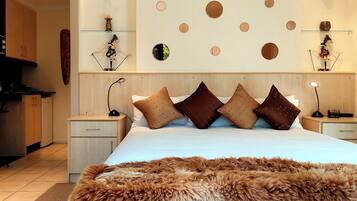 Una habitación de hotel moderna con una cama grande, un tapete mullido y una pared decorada con espejos circulares.