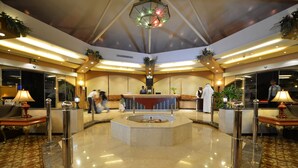 A lobby with a central reception desk, seating areas, and decorative plants. - Boudl Al Malaz (Riyadh)