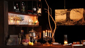 A bar area with shelves of glasses, bottles, and a candle display. - Los Juncos Patagonian Lake House (San Carlos de Bariloche)