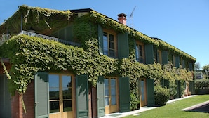 A two-story house with green shutters and ivy-covered walls. - Agriturismo Monteverde (Castelnuovo Magra)