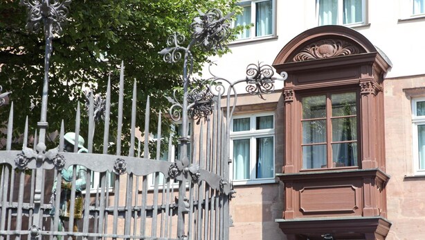 A hotel entrance with a wrought iron gate and a brown awning above the door. - Hotel Hauser (Nuremberg)