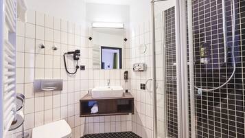 Un baño pequeño con inodoro, lavabo y ducha.